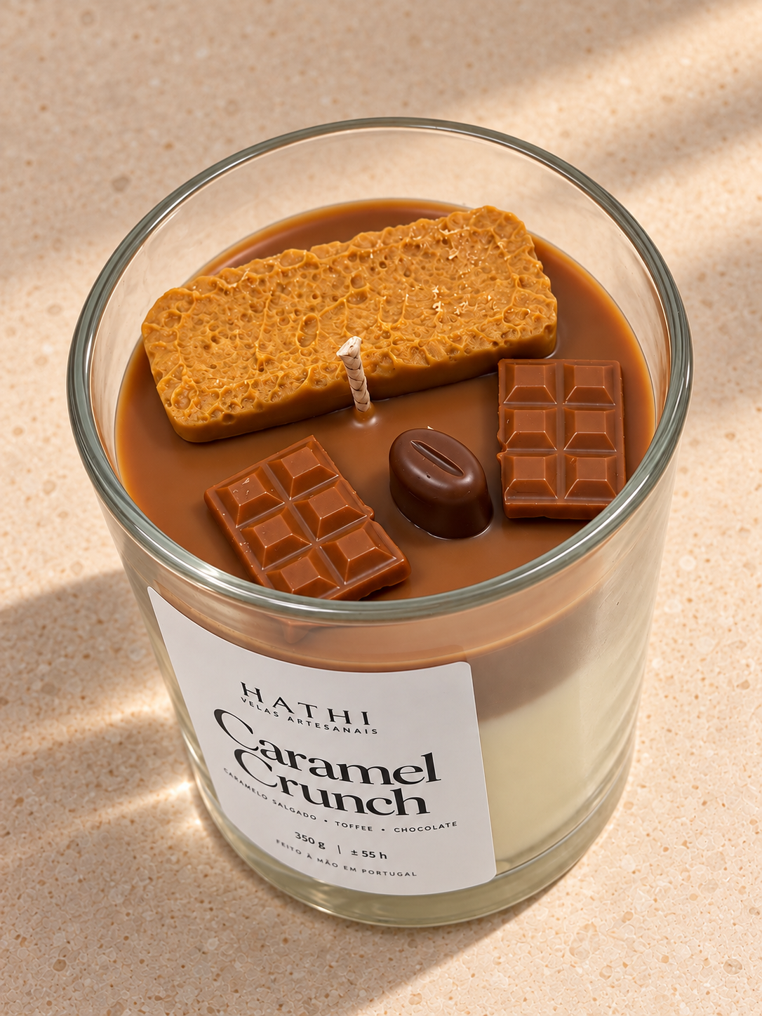 Vela HATHI Caramel Crunch — vista do topo, sobre bancada bege